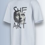 She Art Tee, close-up of 'SHE ART' hand-lettered text.