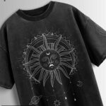 Distressed black oversized T-shirt with a sun and moon graphic and celestial elements.