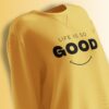 Bright yellow oversized sweatshirt with the phrase 'Life Is So Good' and a minimalistic smiley face.