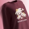 Maroon fleece sweatshirt with a daisy floral design and the phrase 'BLOOM & SHINE' in soft pastel colors.