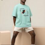 Mint green oversized T-shirt featuring an abstract black chess knight with typography reading 'LIFE COMES A FULL SQUARE'.