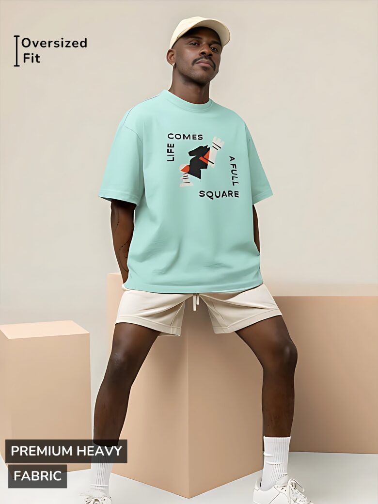 Mint green oversized T-shirt featuring an abstract black chess knight with typography reading 'LIFE COMES A FULL SQUARE'.