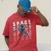 Red oversized T-shirt featuring a floating astronaut with bold 'SPACE' typography in a futuristic design.