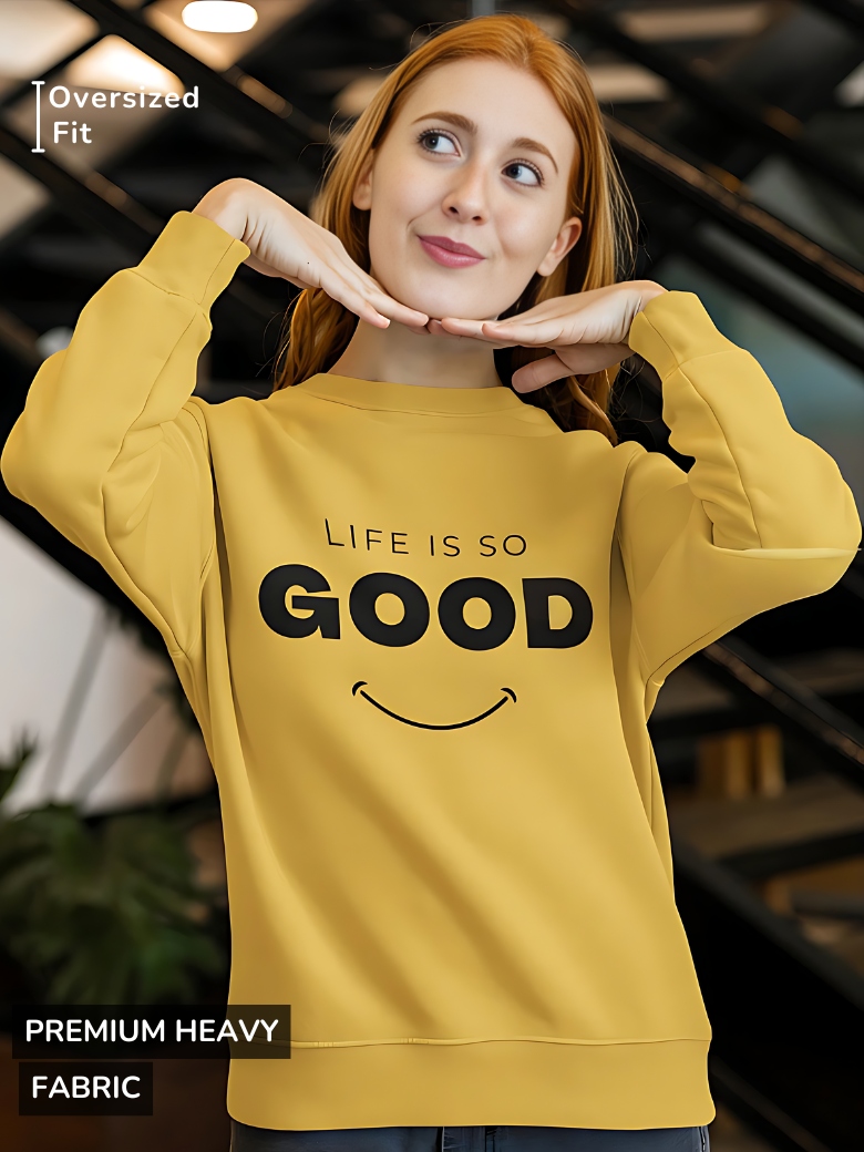 Bright yellow oversized sweatshirt with the phrase 'Life Is So Good' and a minimalistic smiley face.