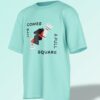 Mint green oversized T-shirt featuring an abstract black chess knight with typography reading 'LIFE COMES A FULL SQUARE'.