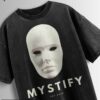 Distressed black oversized T-shirt with a blank mask graphic, 'MYSTIFY' text, and 'EST 2025' text.