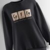 Black sweatshirt featuring a chemistry-inspired design spelling 'Co-Fe' with periodic table elements and the phrase 'Makes Perfect Sense' below.